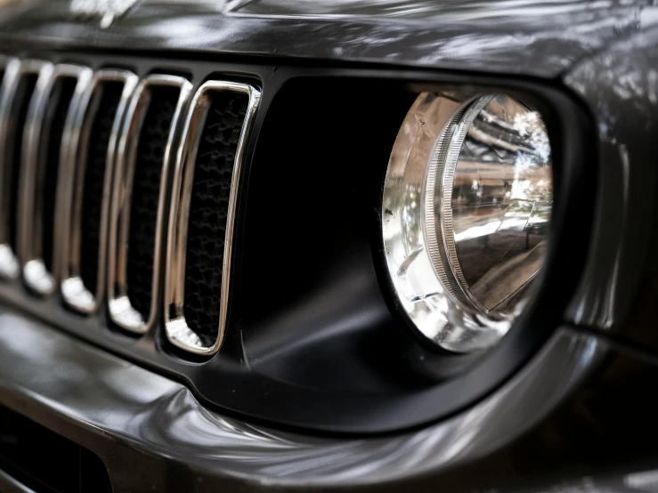 a jeep front grille with a light and black surface