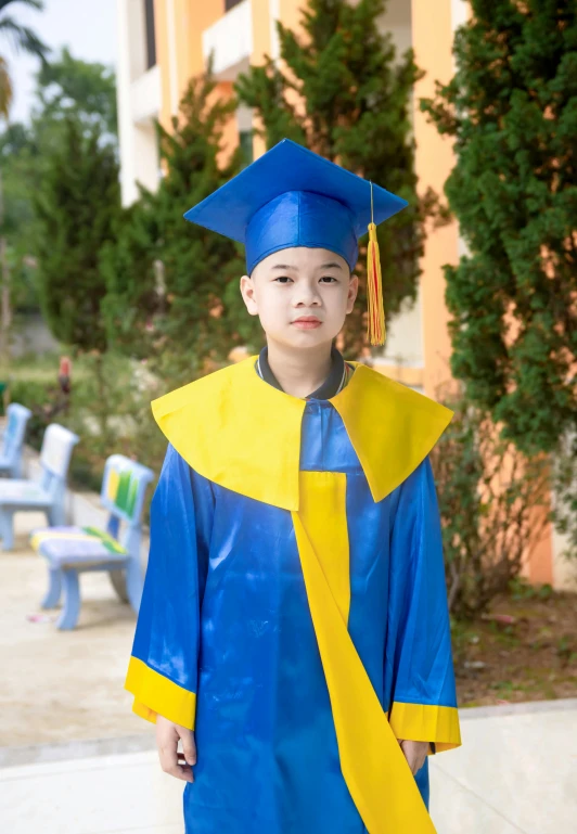 a boy wearing a graduation gown and cap with a tassel in his hands