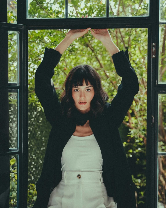 a woman is standing behind a window