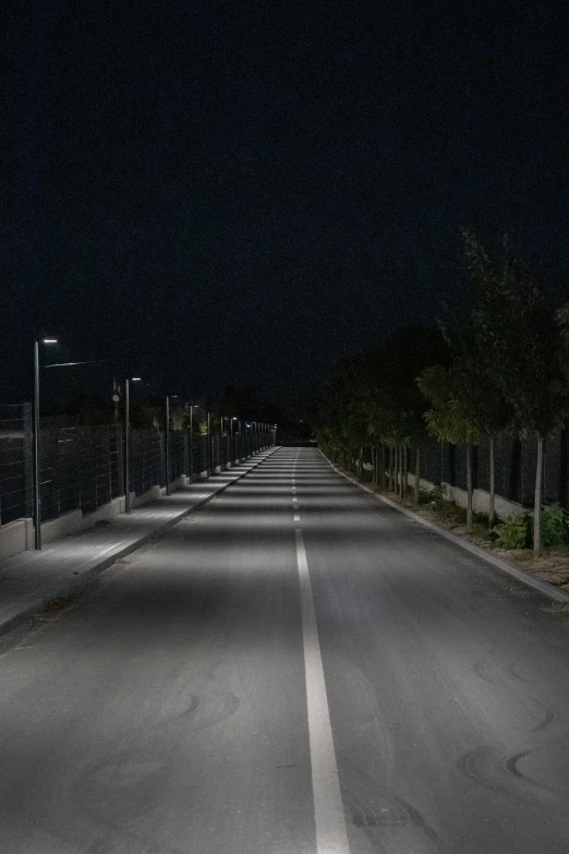 the light at the end of a deserted street shows the glow of a street lamp