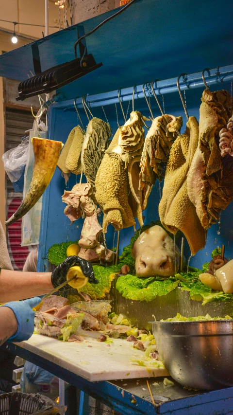 meat hanging from hooks, along with other foods