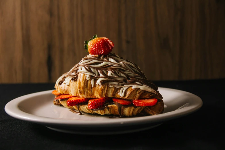 a pastry topped with chocolate and strawberries on a plate