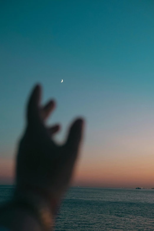 a person is silhouetted against the sky as they watch a moon rise