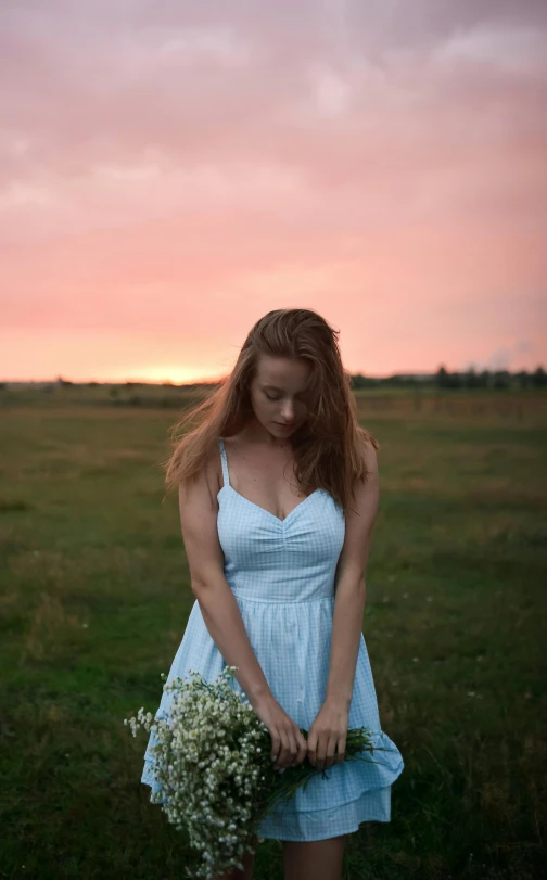 a woman in a blue dress with a white bouquet