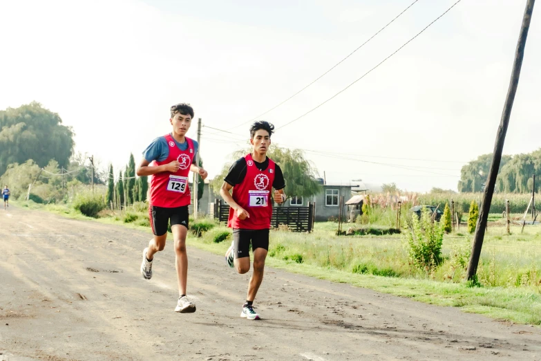 two people running in an event on a dirt road