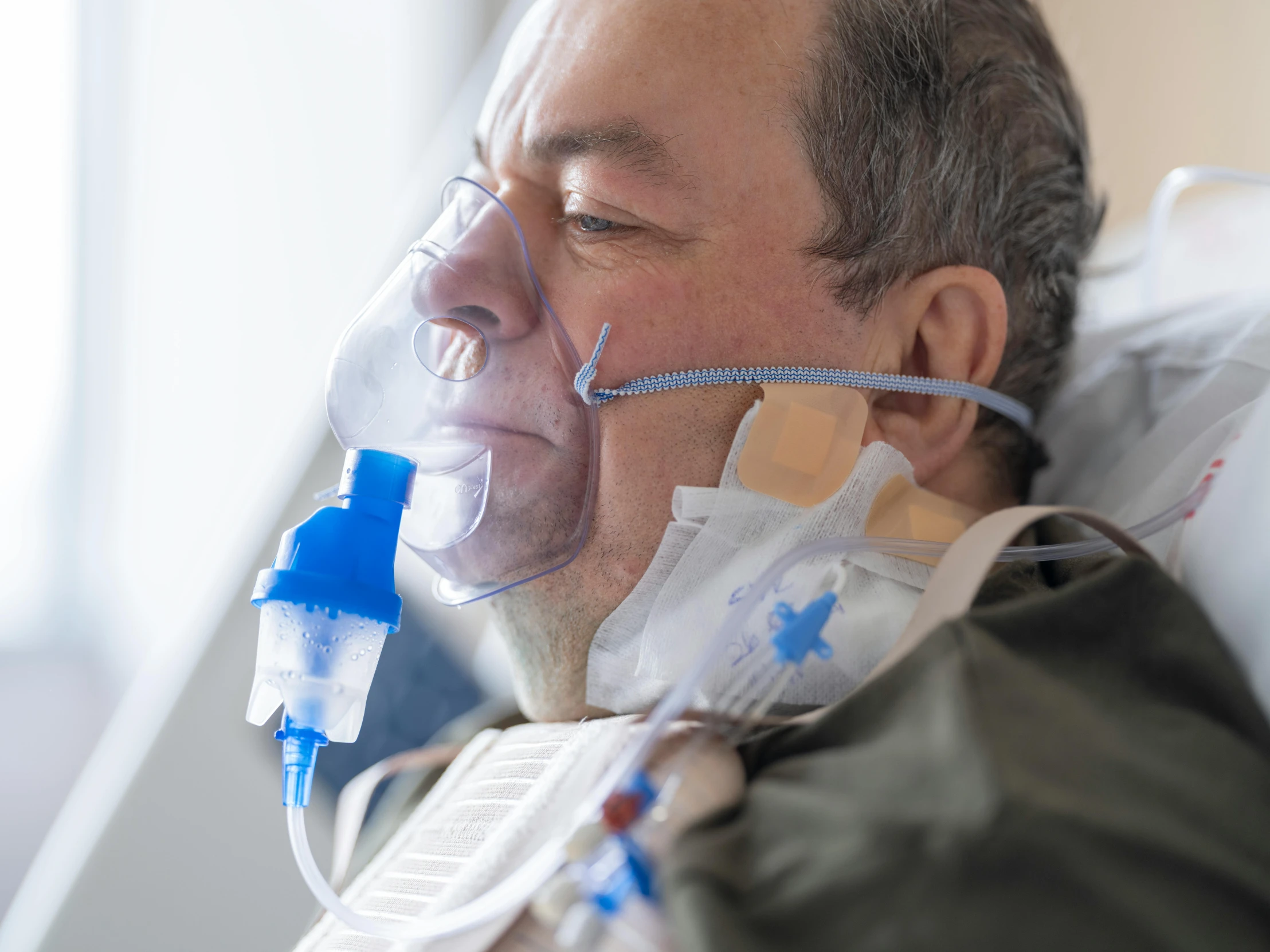 a man is lying down wearing an oxygen tube mask