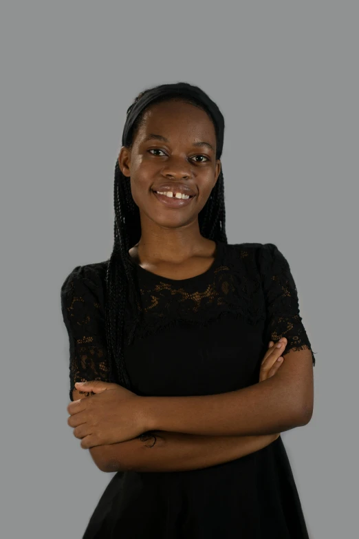 an african woman poses for the camera with her arms crossed