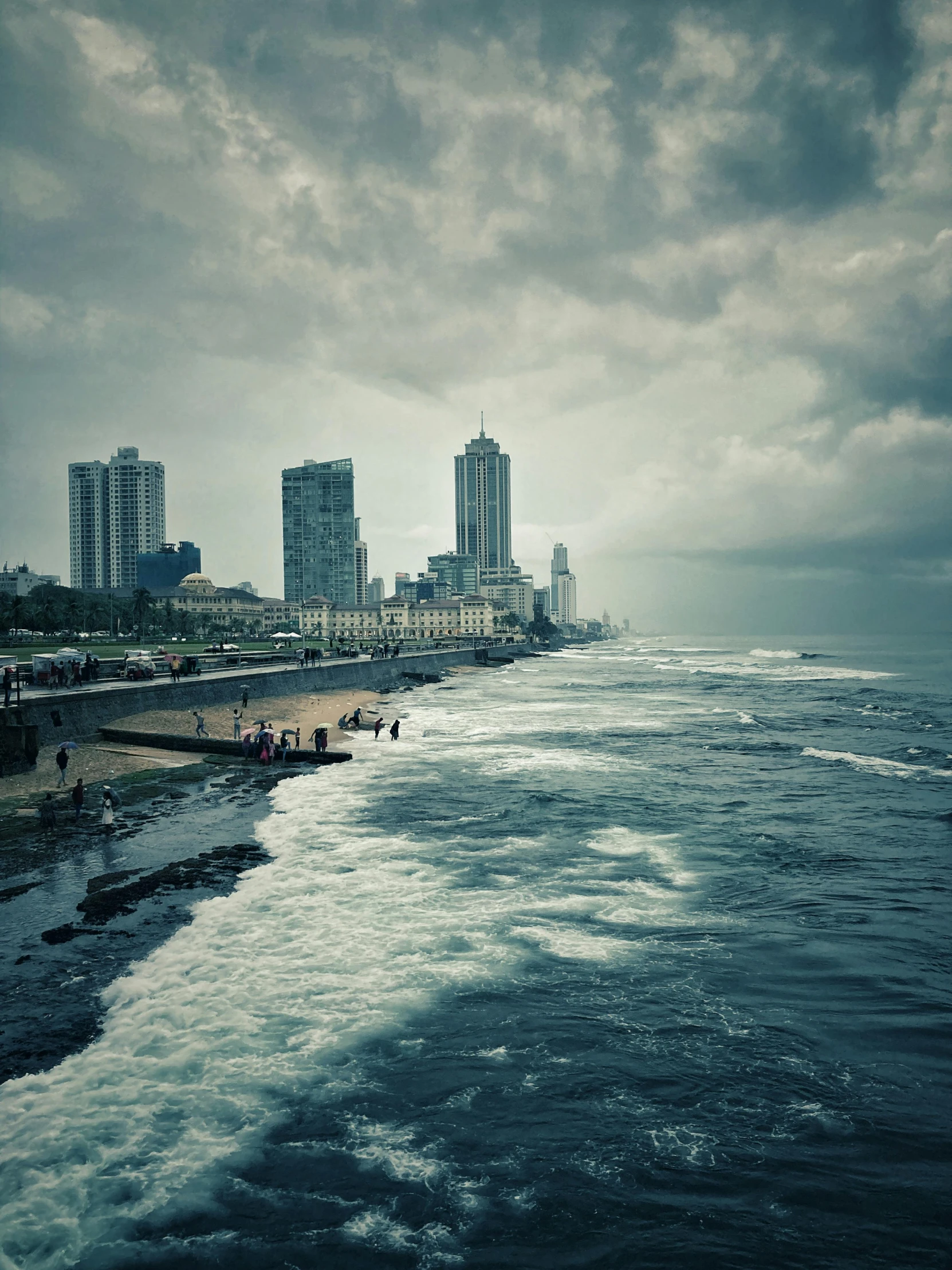 cityscape next to the ocean with people walking