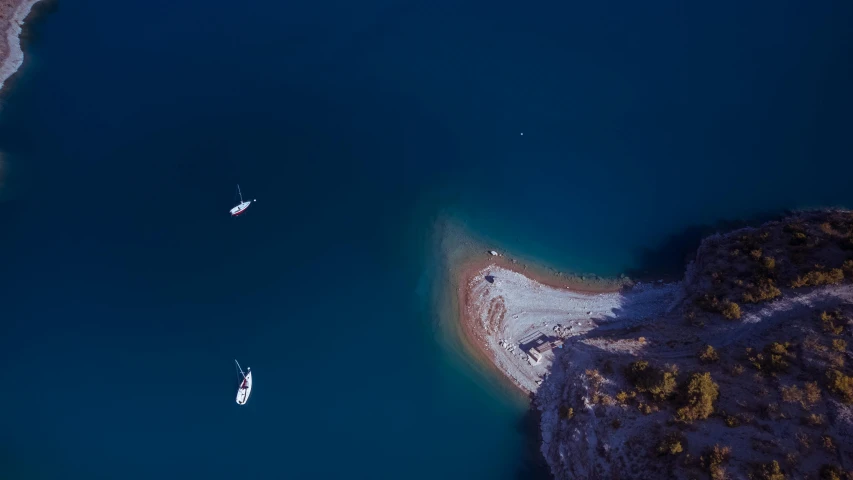 three boats floating in the water near a shore