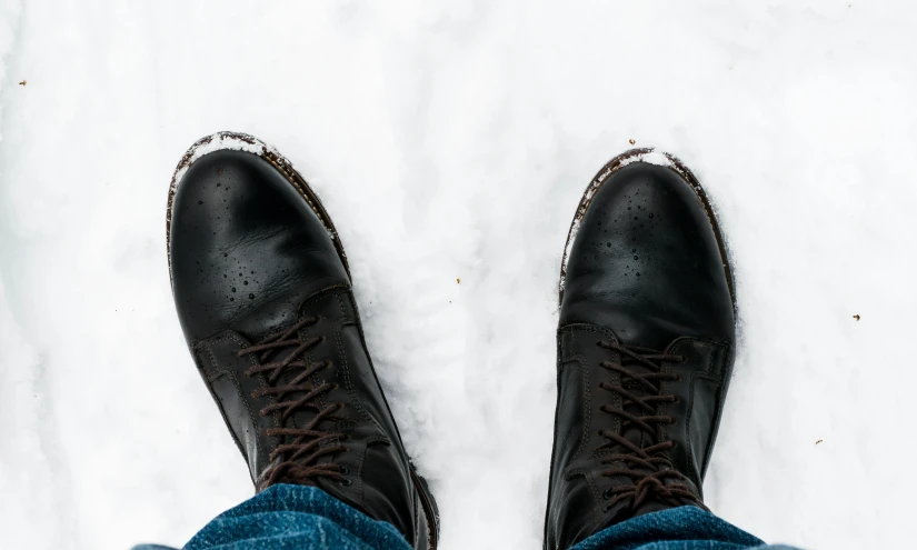 someone is wearing jeans and black shoes in the snow