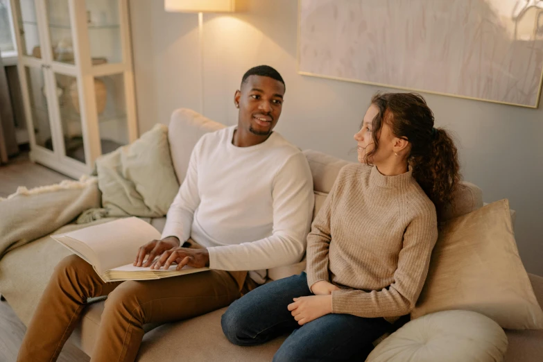 the man and woman are sitting on the couch together