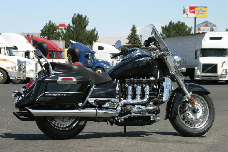 a black motorcycle with chrome trim parked in parking lot