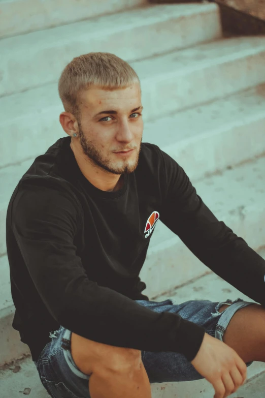 a young man is sitting down on some stairs