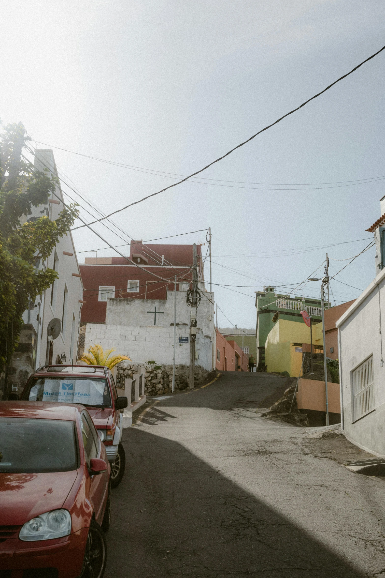 several cars parked in a driveway by buildings