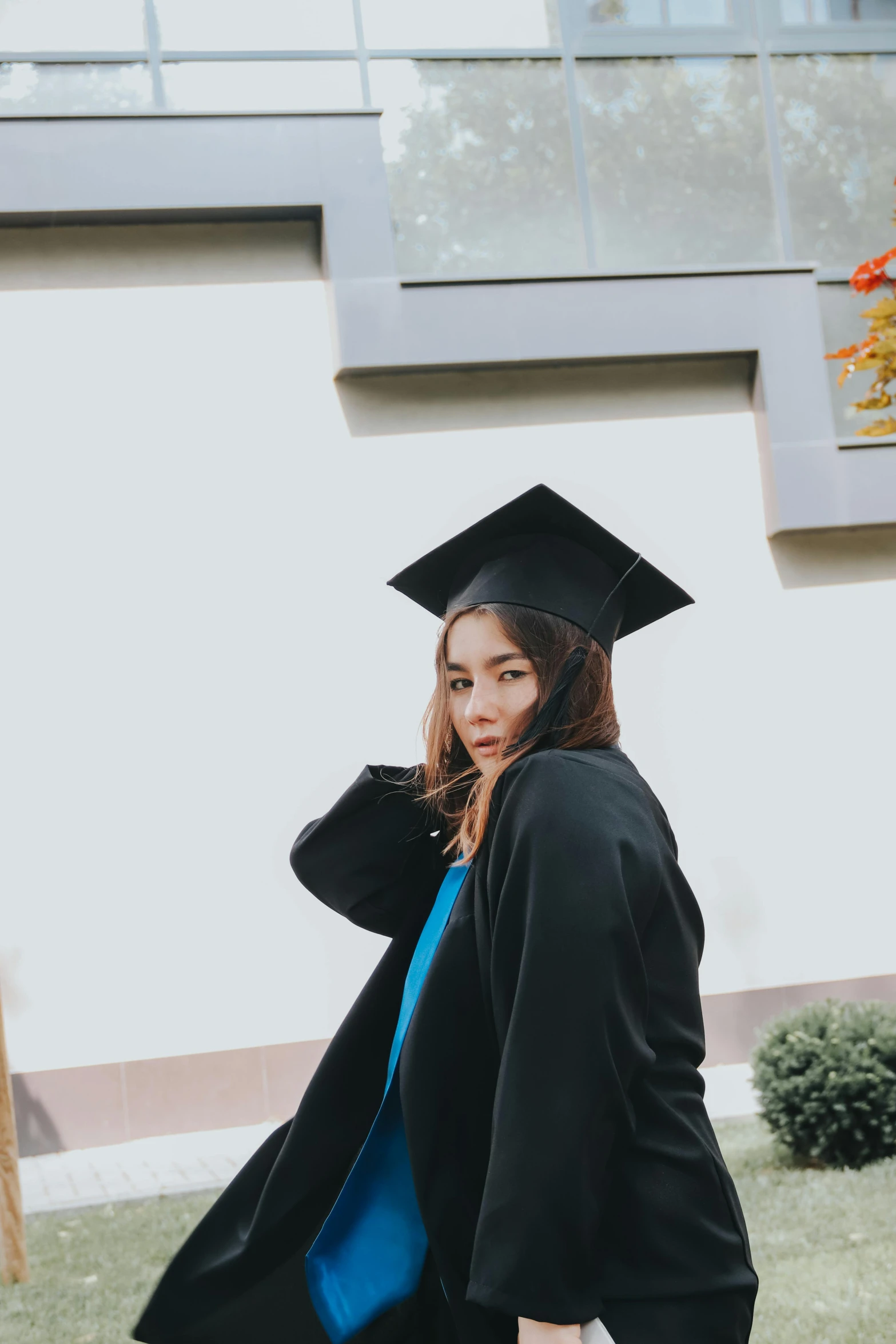 a young female graduate walks near her house