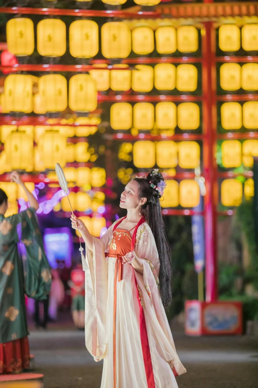 a young asian woman standing in front of the chinese arch at night