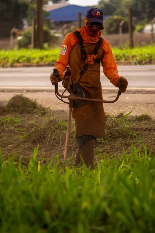 a man using a hose to prune a patch of grass