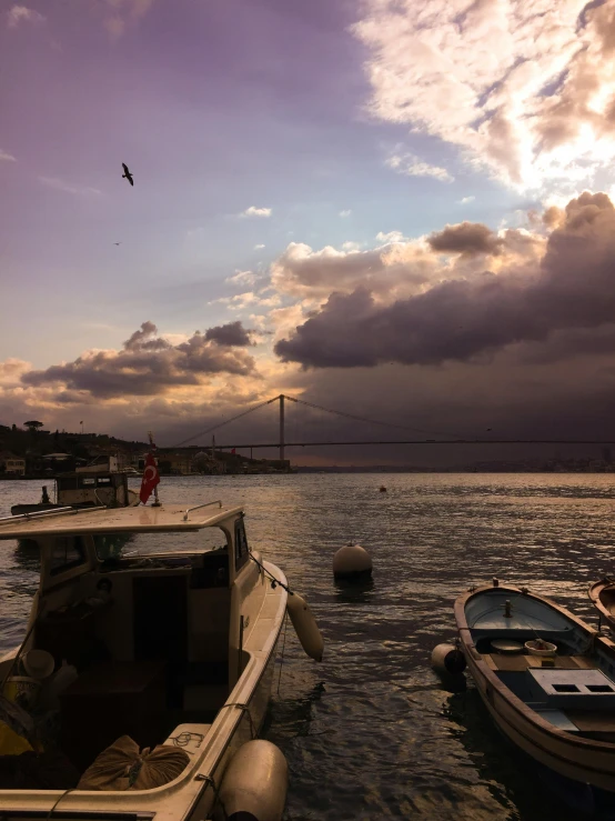 two boats are in the water as a bird flies above them