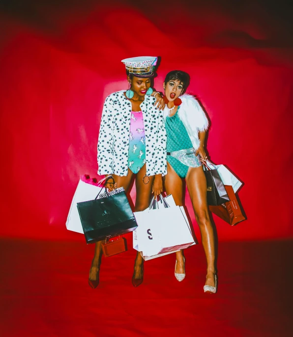 the two women are posing in front of red background