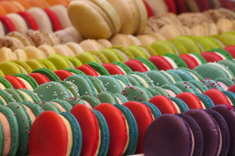 a rack full of macaroons on display with lots of colorful frosting