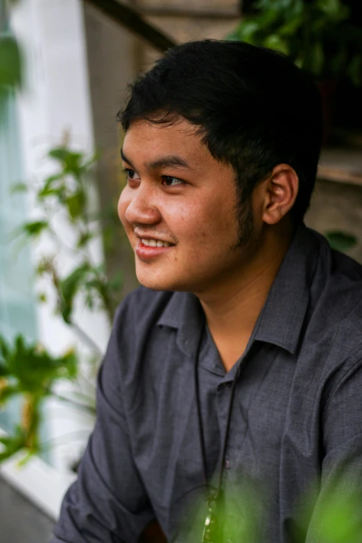 a young man is sitting on the bench and smiling