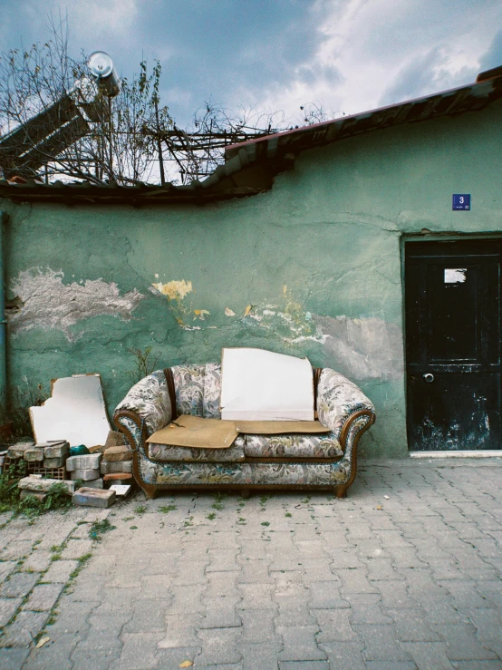 the couch is on the sidewalk by the building