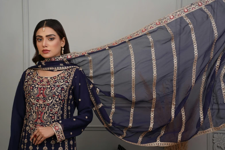 a woman posing in front of a sheered scarf