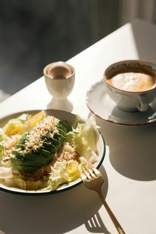 an appetizing plate is served next to a cup of coffee