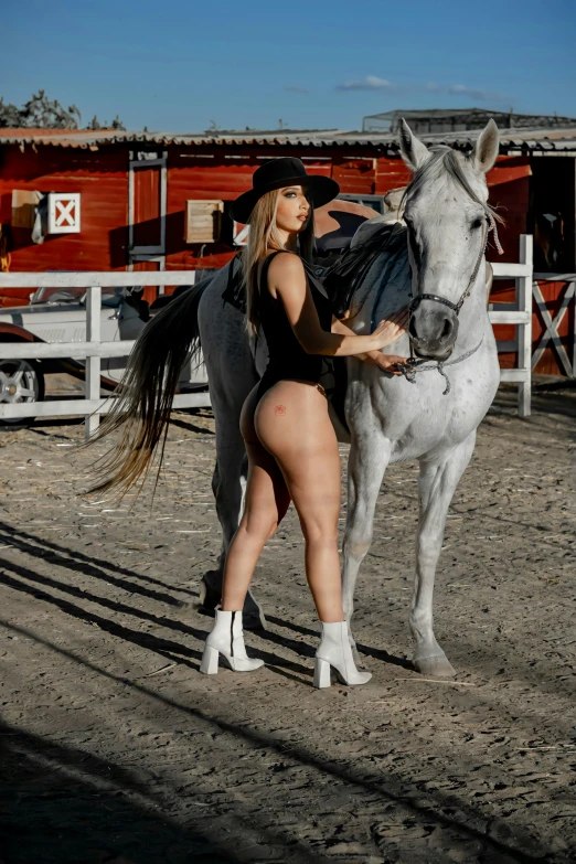 the woman is holding onto the horse and looking into the camera