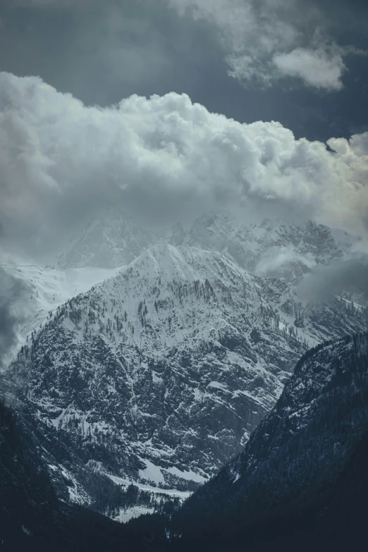 clouds hang over the mountains during a cloudy day