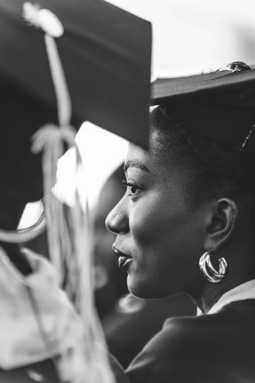 a woman wearing a graduation cap looks out from the audience