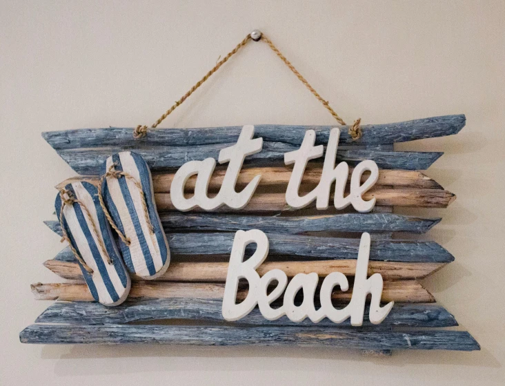 beach decorations hanging on the wall with a sign on it