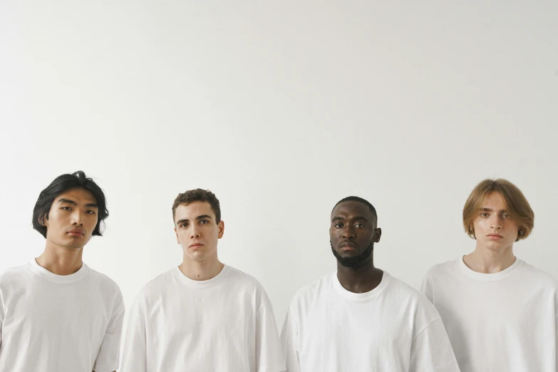 four young men are in white tshirts, one is staring forward