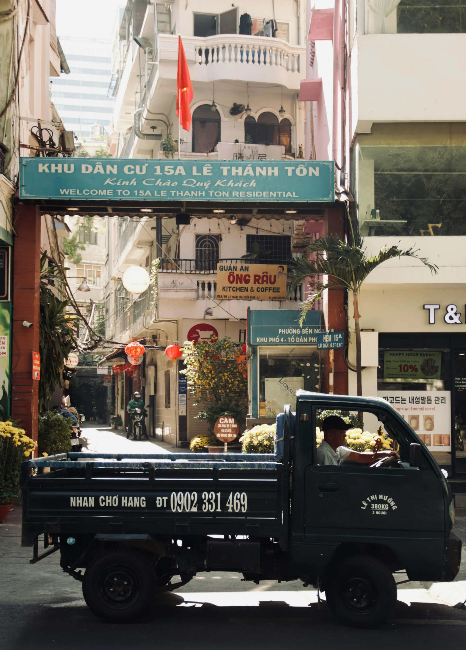 the small black truck is carrying produce down the street