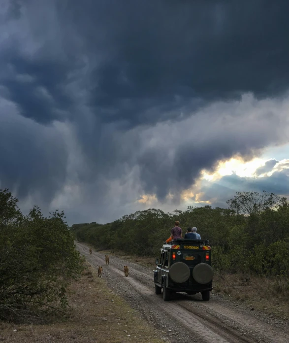 a jeep driving up the road and people on it