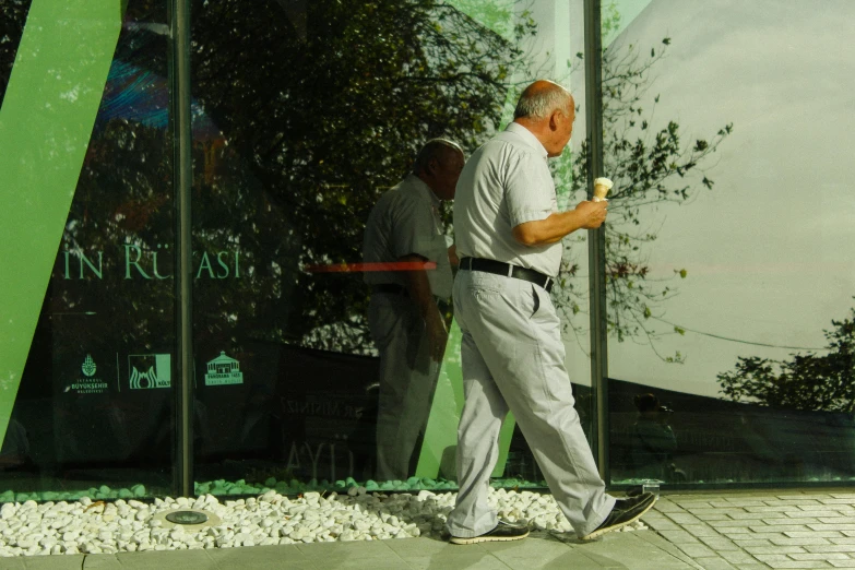 a man that is walking next to a green pole