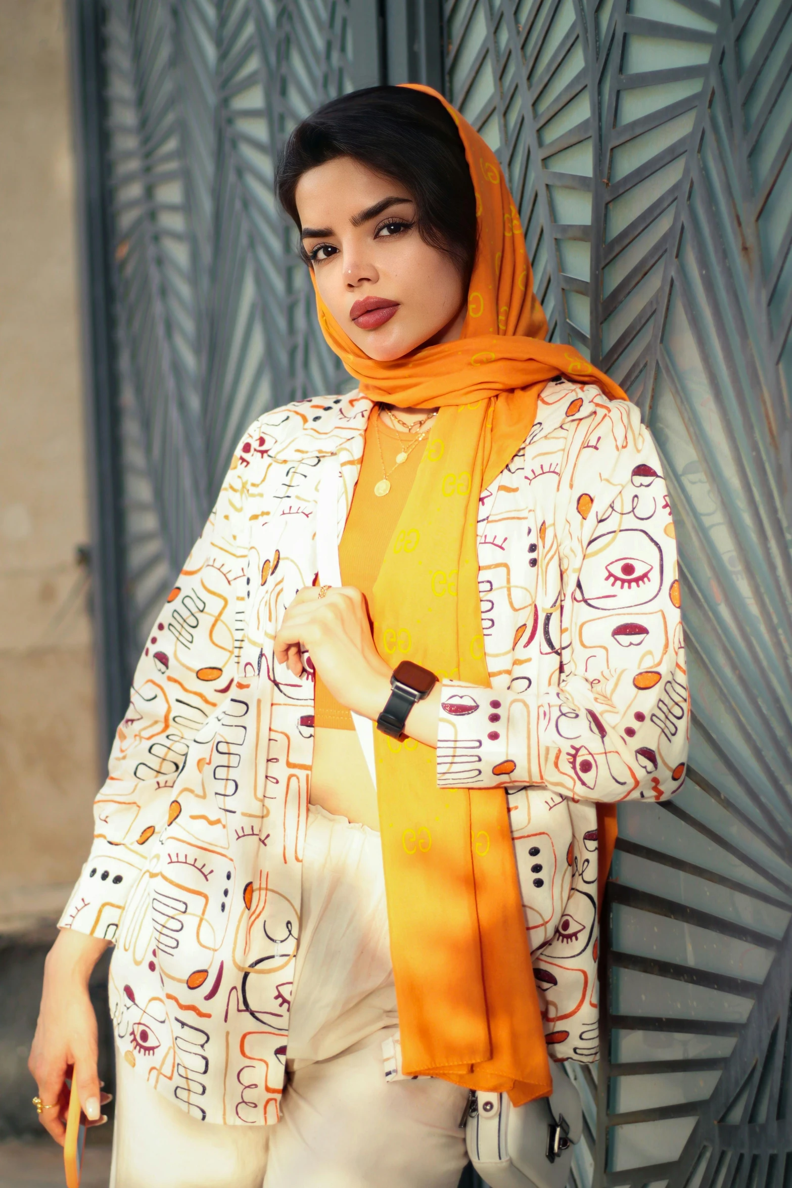 a woman wearing a yellow scarf around her neck and with a colorful shirt with an ornament design on it