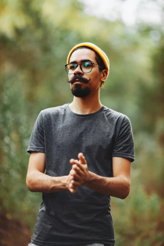 a man standing with glasses and a beanie on his head