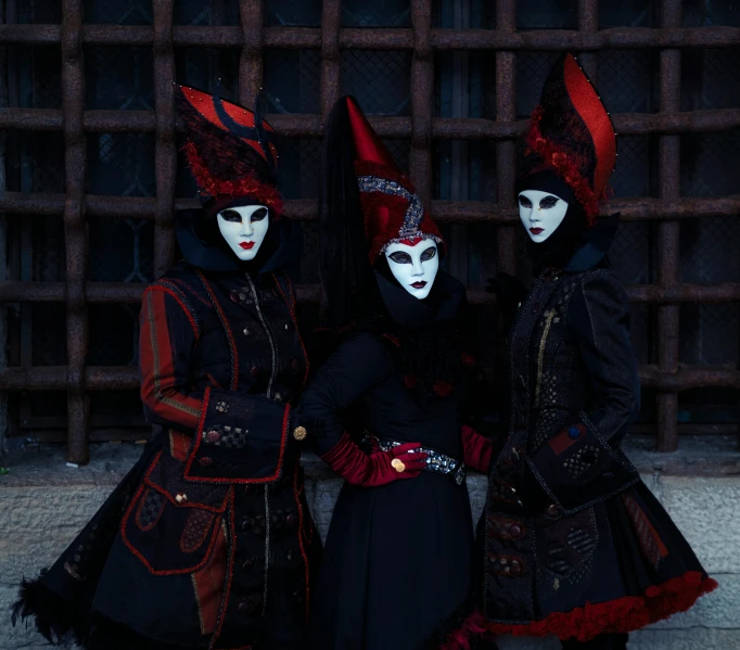 three men in masks dressed in black and red