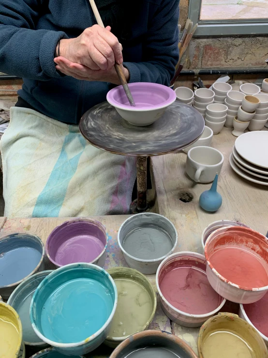 someone is painting an image on a bowl