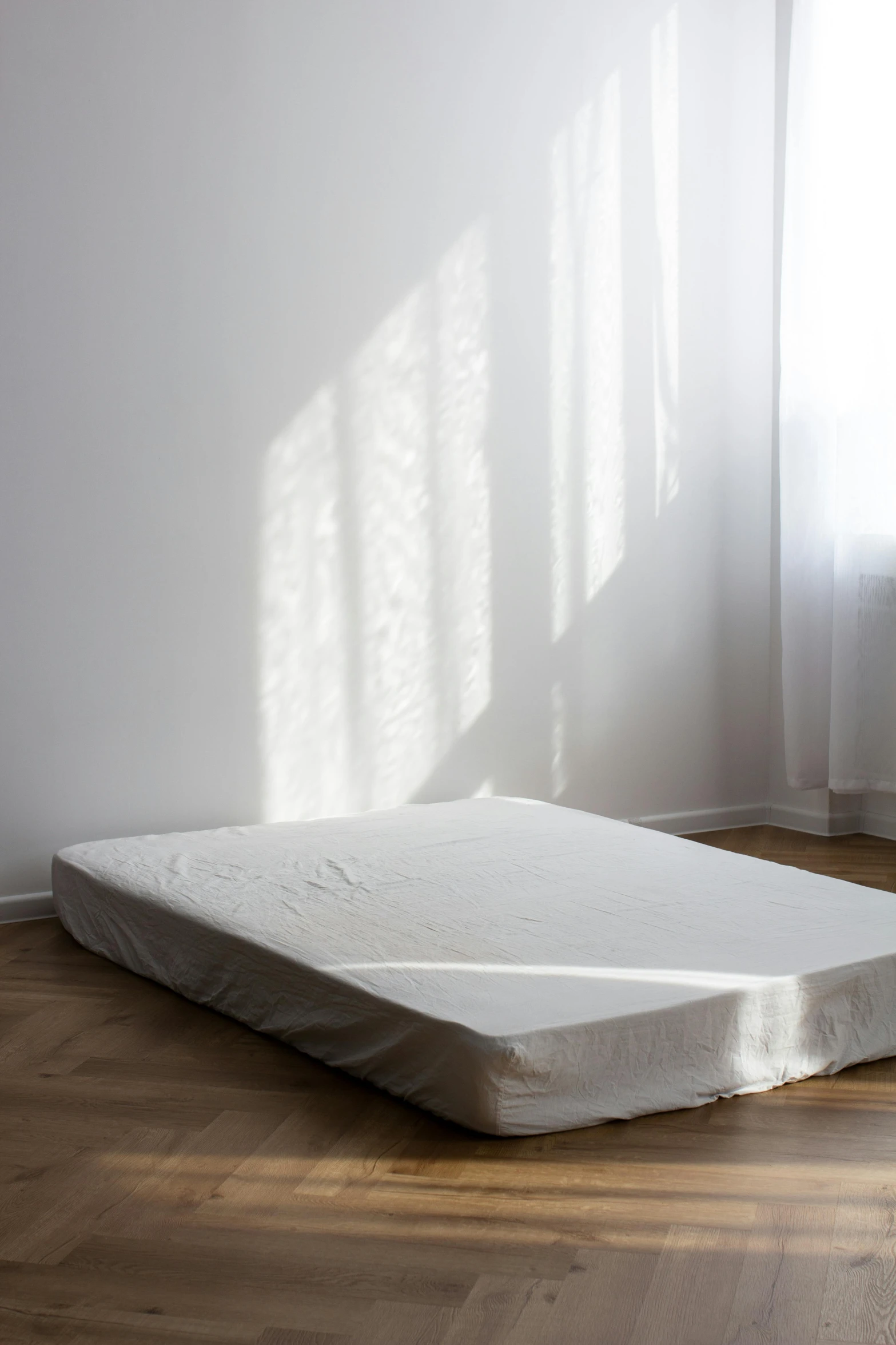 a mattress laying in a room on a wooden floor
