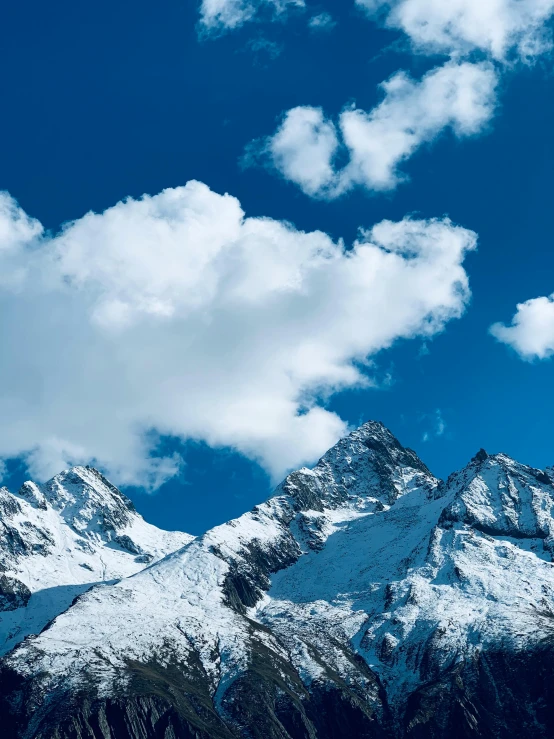 the mountains are very white under a blue sky