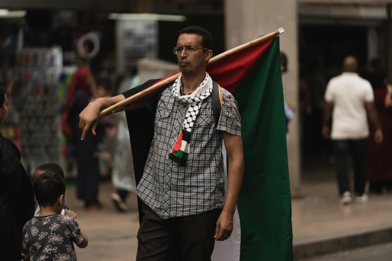 a man carrying a mexican flag on a street