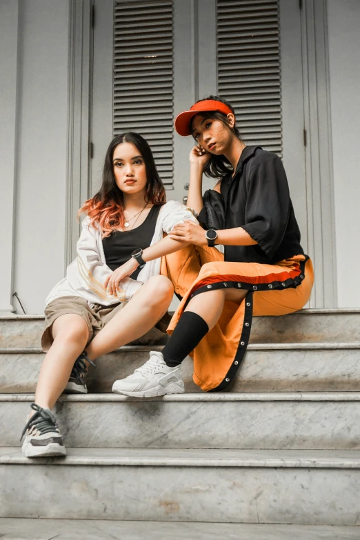 young couple sitting on stairs, looking into camera