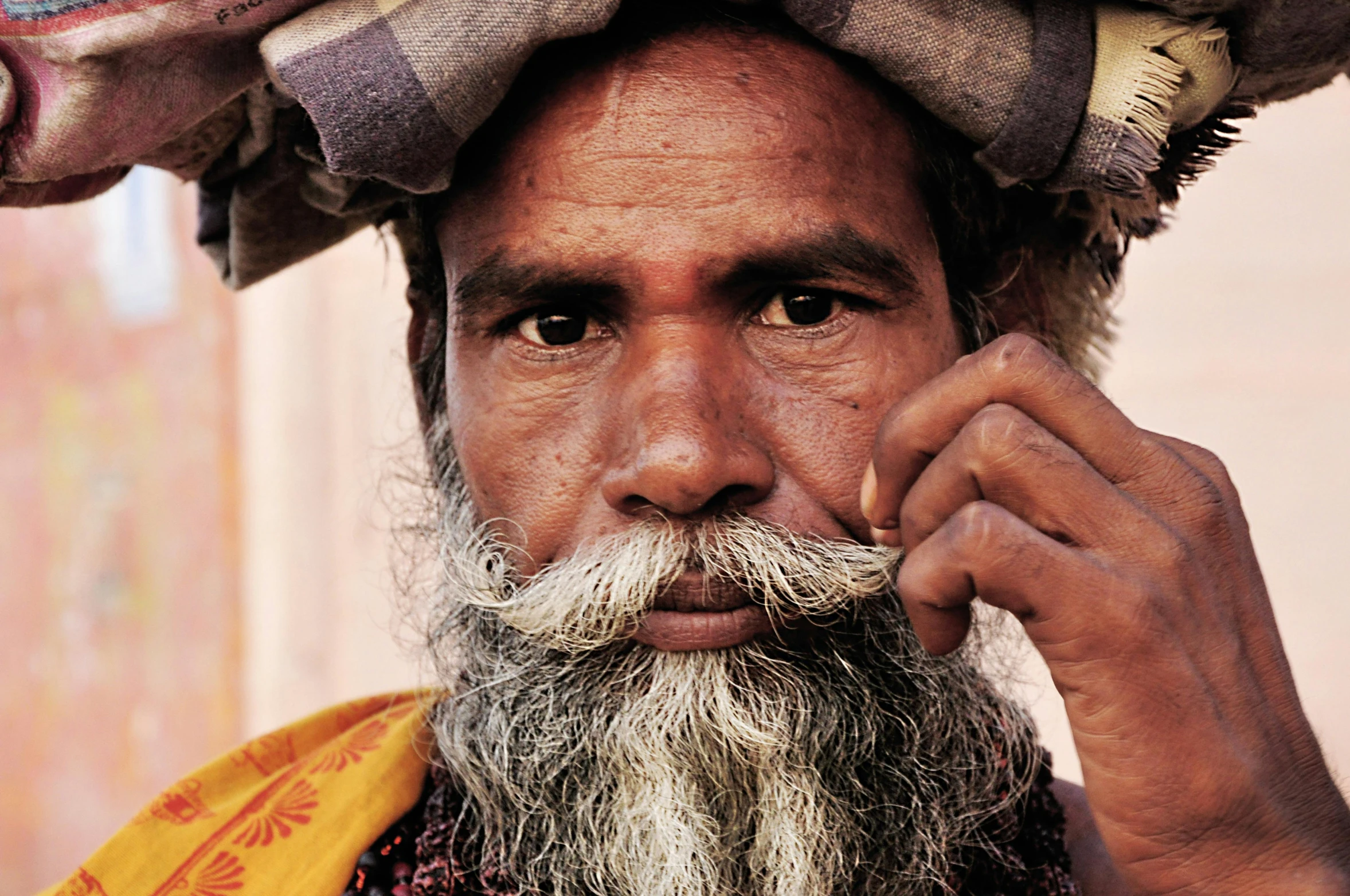 an older man with a goatee and yellow scarf