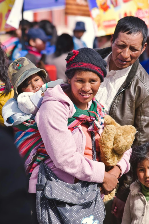 a woman and her child, standing on the street in front of tents