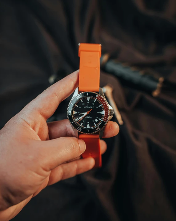 a person holding a wrist watch in their hands