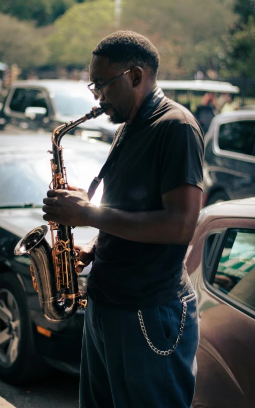 a man playing a saxophone next to a car