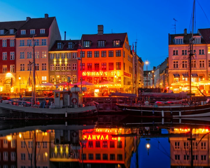 the buildings are next to the water and it looks like they have been lit up