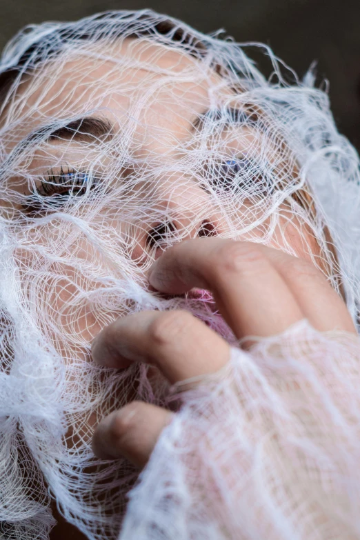 a woman in white clothing wearing net netting